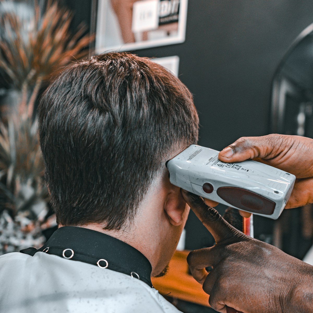 Stylistin föhnt und stylt das Haar einer Kundin